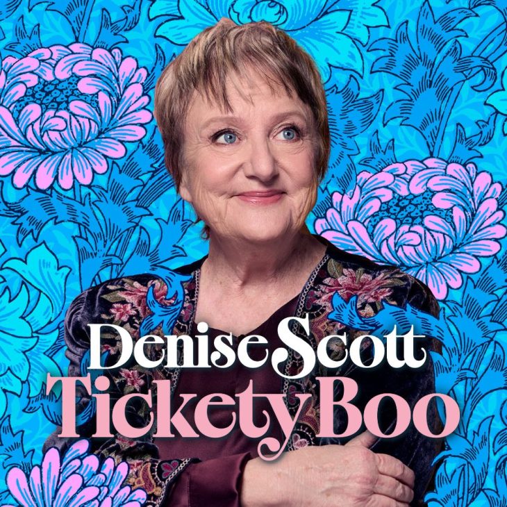 Denise Scott smiles in front of a blue and pink floral background. The words Denise Scott Tickety Boo in the foreground.