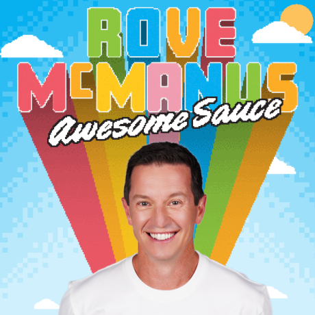 Rove McManus is facing the camera, smiling brightly with his stark white teeth showing. He wears a white t-shirt. He has short dark hair and dark eyes. The background is a digital blue sky with white clouds, one with a yellow sun behind it.