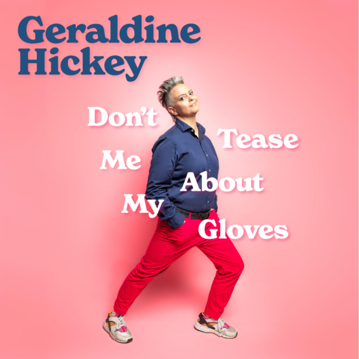 Image is of Geraldine Hickey. Geraldine has short grey hair and brown eyes. Her body is positioned toward the right and her head is turned forward staring directly into the camera. She is wearing a navy blue buttoned up top, bright pink pants, a black belt and white sneakers.