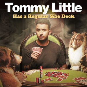 Image is of a surreal illustration of Tommy Little. Tommy has short brown hair, stubble and black tattoos on his arm. He is wearing a black t-shirt. Tommy is sitting around table playing poker with dogs. He is holding playing cards and raising an eyebrow toward the camera lens.
