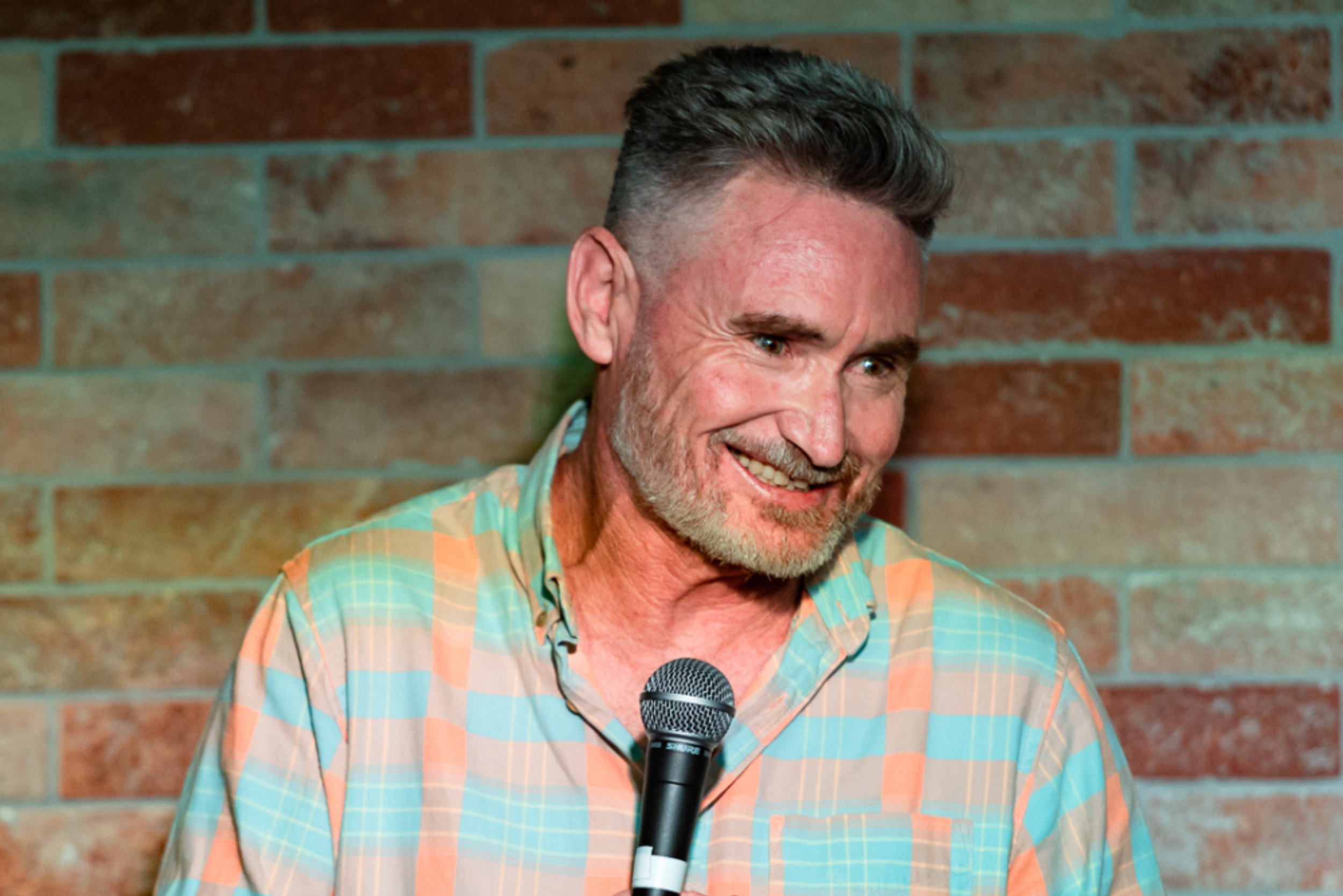 Image is of Dave Hughes doing stand up comedy